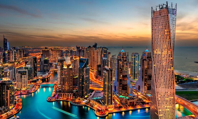 Vista panorâmica de Dubai ao pôr do sol, com destaque para edifícios de luxo e marina milionária.