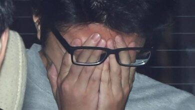 Takahiro Shiraishi cobre o rosto com as mãos enquanto é transportado de uma delegacia de polícia em Tóquio para o Ministério Público. em 2017