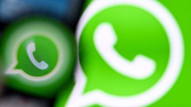 A imagem mostra o logotipo do WhatsApp em um fundo verde. O logotipo é composto por um balão de diálogo com um telefone dentro. A imagem está desfocada, com um efeito de desfoque que destaca o logotipo em primeiro plano.