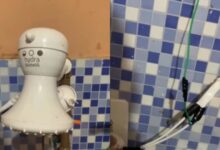 Chuveiro elétrico adaptado na pia com fios expostos e risco de curto-circuito.