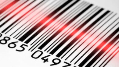 Feixe de laser vermelho escaneando um código de barras branco e preto.
