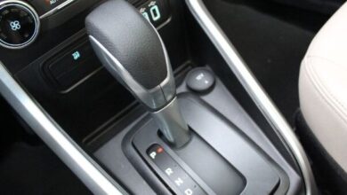 Desligar um carro automático pode parecer uma tarefa simples, mas se não for feito corretamente, pode causar danos significativos à transmissão e resultar em altos custos. Com a crescente popularidade dos carros automáticos no Brasil, é essencial que motoristas compreendam a maneira correta de desligar esses veículos para evitar prejuízos. Cometer erros como engatar a marcha em "P" (Parking) antes de o carro estar completamente parado pode comprometer o funcionamento a longo prazo. Entendendo os Riscos Os problemas ao desligar um carro automático de forma inadequada não se limitam apenas à transmissão. Engates errados podem causar trancos e desgastes prematuros. Em declives, acionar o "P" antes do freio de mão pode sobrecarregar o sistema, levando a avarias. Além disso, motoristas de carros com motor turbo devem esperar alguns segundos antes de desligar o motor para proteger o sistema de lubrificação. Procedimento Correto para Desligar Para garantir a segurança e a longevidade da transmissão, siga o procedimento correto de desligamento: Certifique-se de que o veículo está totalmente parado. Mantenha o pé no freio e mude a alavanca para "N" (Neutro). Acione o freio de mão, garantindo que o peso do carro seja suportado adequadamente. Engate a alavanca em "P". Desligue o motor. Esta sequência não só preserva a transmissão como também aumenta a segurança ao estacionar. Evitando Falhas Futuras Entender os riscos associados ao desligamento inadequado ajuda a evitar falhas no carro. Práticas incorretas podem afetar componentes elétricos e resultar em mensagens de erro no painel. O uso correto da posição "N" e a sequência apropriada são essenciais para evitar trancos em superfícies inclinadas e para preservar o funcionamento do veículo. Benefícios de Pequenos Cuidados Adotar práticas corretas ao desligar um carro automático é mais do que uma questão de evitar reparos dispendiosos. É um investimento na longevidade e eficiência do veículo. Com motoristas cada vez mais optando por modelos automáticos, o conhecimento das melhores práticas de desligamento se torna indispensável. Informações adequadas e a implementação desses cuidados no dia a dia podem prevenir muitos problemas futuros e garantir que seu carro esteja sempre em ótimas condições de uso. Em outubro de 2023, o aumento da frota de veículos automáticos no Brasil destaca a importância de seguir esses passos corretos de desligamento. Proteger seu investimento e garantir uma condução mais tranquila são razões suficientes para adotar essas práticas.