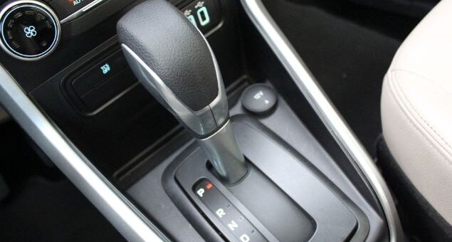 Desligar um carro automático pode parecer uma tarefa simples, mas se não for feito corretamente, pode causar danos significativos à transmissão e resultar em altos custos. Com a crescente popularidade dos carros automáticos no Brasil, é essencial que motoristas compreendam a maneira correta de desligar esses veículos para evitar prejuízos. Cometer erros como engatar a marcha em "P" (Parking) antes de o carro estar completamente parado pode comprometer o funcionamento a longo prazo. Entendendo os Riscos Os problemas ao desligar um carro automático de forma inadequada não se limitam apenas à transmissão. Engates errados podem causar trancos e desgastes prematuros. Em declives, acionar o "P" antes do freio de mão pode sobrecarregar o sistema, levando a avarias. Além disso, motoristas de carros com motor turbo devem esperar alguns segundos antes de desligar o motor para proteger o sistema de lubrificação. Procedimento Correto para Desligar Para garantir a segurança e a longevidade da transmissão, siga o procedimento correto de desligamento: Certifique-se de que o veículo está totalmente parado. Mantenha o pé no freio e mude a alavanca para "N" (Neutro). Acione o freio de mão, garantindo que o peso do carro seja suportado adequadamente. Engate a alavanca em "P". Desligue o motor. Esta sequência não só preserva a transmissão como também aumenta a segurança ao estacionar. Evitando Falhas Futuras Entender os riscos associados ao desligamento inadequado ajuda a evitar falhas no carro. Práticas incorretas podem afetar componentes elétricos e resultar em mensagens de erro no painel. O uso correto da posição "N" e a sequência apropriada são essenciais para evitar trancos em superfícies inclinadas e para preservar o funcionamento do veículo. Benefícios de Pequenos Cuidados Adotar práticas corretas ao desligar um carro automático é mais do que uma questão de evitar reparos dispendiosos. É um investimento na longevidade e eficiência do veículo. Com motoristas cada vez mais optando por modelos automáticos, o conhecimento das melhores práticas de desligamento se torna indispensável. Informações adequadas e a implementação desses cuidados no dia a dia podem prevenir muitos problemas futuros e garantir que seu carro esteja sempre em ótimas condições de uso. Em outubro de 2023, o aumento da frota de veículos automáticos no Brasil destaca a importância de seguir esses passos corretos de desligamento. Proteger seu investimento e garantir uma condução mais tranquila são razões suficientes para adotar essas práticas.