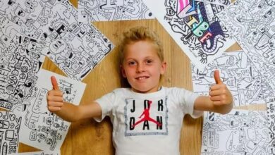Joe Whale desenhando em seu quarto com obras nas paredes e caixas da Nike ao redor