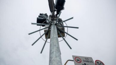 Dispositivo de proteção metálica instalado em radar de trânsito em São Paulo, visto de baixo, destacando tecnologia contra furtos e sinalização viária.
