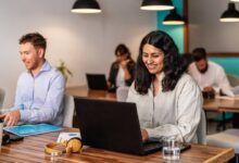 Profissionais trabalhando em escritório moderno com notebooks e ambiente colaborativo