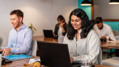 Profissionais trabalhando em escritório moderno com notebooks e ambiente colaborativo