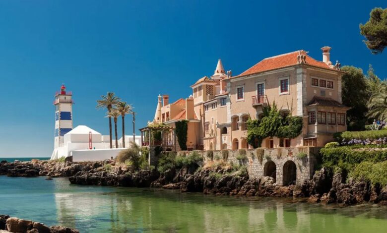 Vista aérea da Baía de Cascais com imóveis de luxo à beira-mar.