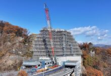 Na rodovia Joshinetsu, no Japão, engenheiros conduzem a remoção de rocha mais desafiadora do mundo sob um andaime de 70 metros, em um projeto da Obayashi Corporation que prioriza segurança total — sem fechar a via nem deixar cair uma única pedra.