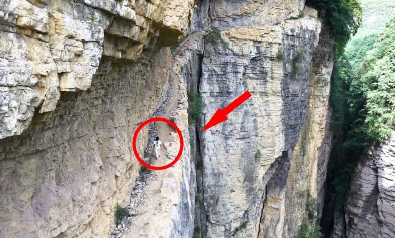 Em Guizhou, uma estrada de tábuas escavada em um penhasco abriga um antigo canal construído por moradores locais, símbolo de coragem e precisão.