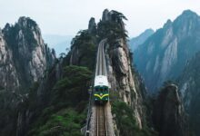 A ferrovia pendurada em Huangshan eleva viajantes a 500 metros de altura sobre penhascos, cruzando a montanha de Huangshan e o parque de Huangshan em minutos. O trajeto combina o teleférico Yungu, trilhas panorâmicas e o lendário mar de nuvens, revelando a experiência mais impressionante da China moderna.