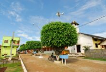 Vista urbana de Marechal Thaumaturgo com avião sobrevoando a cidade, mostrando o isolamento e o acesso aéreo típico da região amazônica.