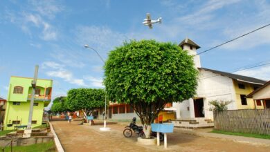 Vista urbana de Marechal Thaumaturgo com avião sobrevoando a cidade, mostrando o isolamento e o acesso aéreo típico da região amazônica.